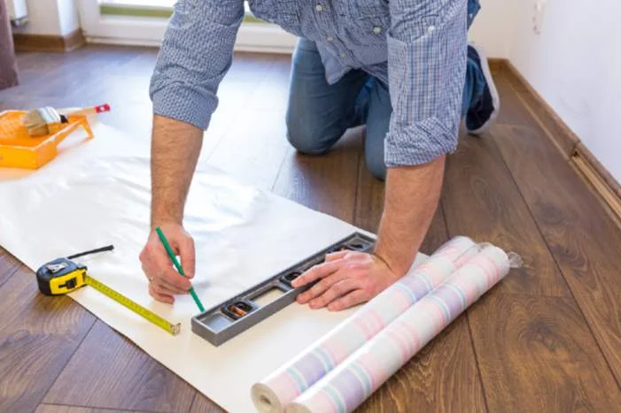 Person zeichnet mit Bleistift auf Tapete